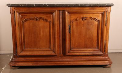 une armoire en bois posée au sol, avec un plateau en marbre