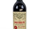 the bottle of red wine is sitting on a white surface
