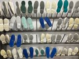 de nombreuses paires de chaussures suspendues à un porte-chaussures dans une pièce