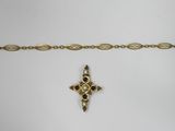 a close up of a gold bracelet with a cross on it