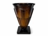a brown glass vase with a black base on a white background