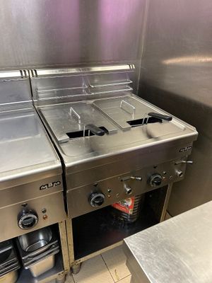 trois cuisinières en acier inoxydable dans une cuisine professionnelle
