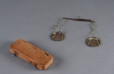 une petite boîte en bois sur laquelle est représentée une balance