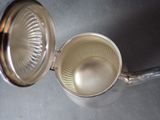 a silver juicer with a lid on a table