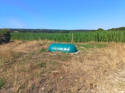 un tonneau bleu posé au milieu d'un champ