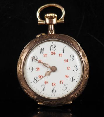 a close up of a gold pocket watch on a black surface