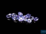 a close up of a bunch of purple sapphires on a black surface