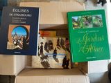 de nombreux livres qui sont rangés dans une boîte posée par terre