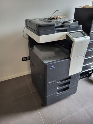 une imprimante posée sur une commode à tiroirs