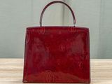 a red handbag sitting on top of a wooden table
