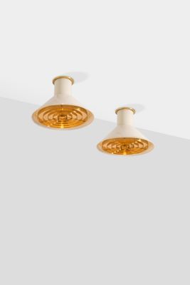 a pair of white and gold earrings on a white surface