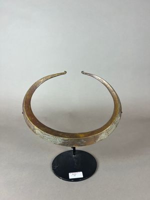 un gros plan d'un objet métallique posé sur un socle, sur fond blanc