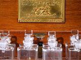a wooden case with glass bottles and a brass plaque on it