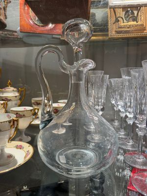 many glasses and a decanter sitting on a table