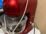 un robot ménager rouge posé sur un réfrigérateur blanc