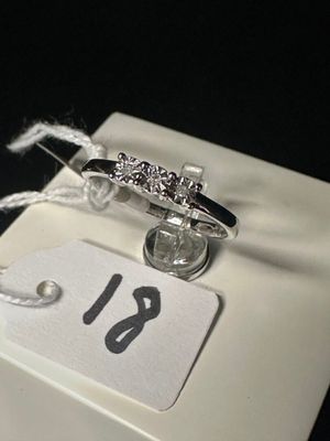 une bague posée sur une boîte blanche avec une étiquette de prix