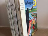 several children ' s books stacked on top of each other on the floor