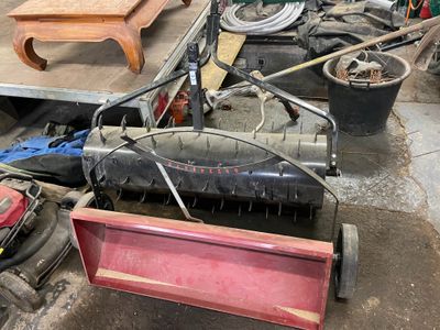 a lawn mower sitting on the ground next to other items
