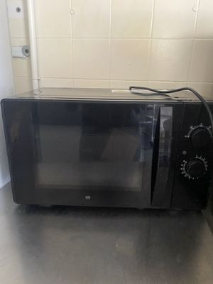 a black microwave sitting on a counter in a kitchen