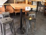 des tables et des tabourets dans un restaurant aux murs et aux escaliers en pierre