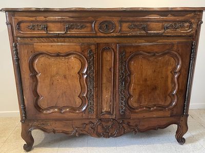 une vieille armoire en bois ornée de sculptures élaborées sur le dessus