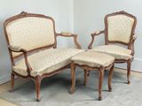 two chairs and a ottoman in the corner of a room