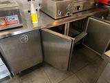 une cuisine avec de nombreux plans de travail en inox