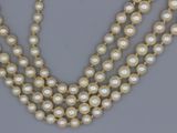 un gros plan d'un collier orné de perles sur un fond gris