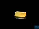 a yellow jade stone on a black surface
