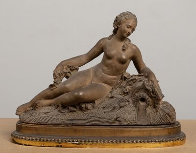 statue of a woman sitting on a rock with a dog in her lap