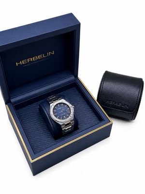 un gros plan sur une montre dans un coffret, à côté d'un portefeuille