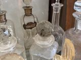 many glass bottles sitting on a glass shelf next to each other