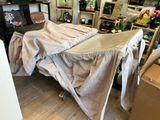 un lit recouvert d'un drap au milieu d'une pièce
