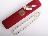 a red case with pearls and a gold medal on it