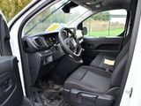 the interior of a white truck with the door open and the driver ' s seat down