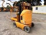 a yellow forklift sitting in the middle of a parking lot