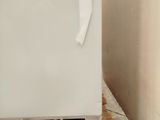 a white refrigerator sitting on top of a wooden pallet