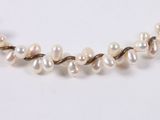 a close up of a white pearl necklace on a white surface