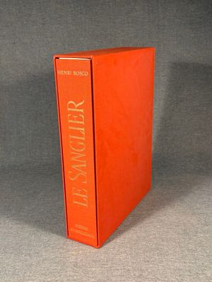 an orange book sitting on top of a table next to a gray wall