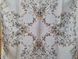 a close up of a white table cloth with flowers on it