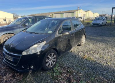 La petite voiture noire est garée sur le parking, à côté d'autres voitures.