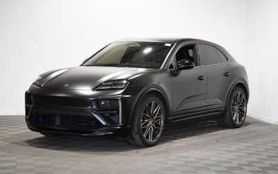 Une Porsche Cayenne grise est garée dans une pièce blanche