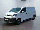 La camionnette blanche est garée dans une grande pièce équipée d'un ventilateur de plafond.