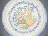 a blue and white plate with a yellow vase on it
