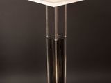 a white table with a black base and a white light on top