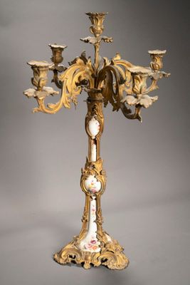 un lustre doré et blanc surmonté d'une horloge