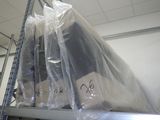 une étagère sur laquelle sont empilés de nombreux équipements informatiques emballés dans du plastique