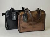 two bags with tags on them sitting next to each other