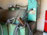 une machine verte qui se trouve à côté d'une poubelle rouge