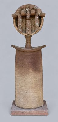 a small vase with a sculpture on top of it
